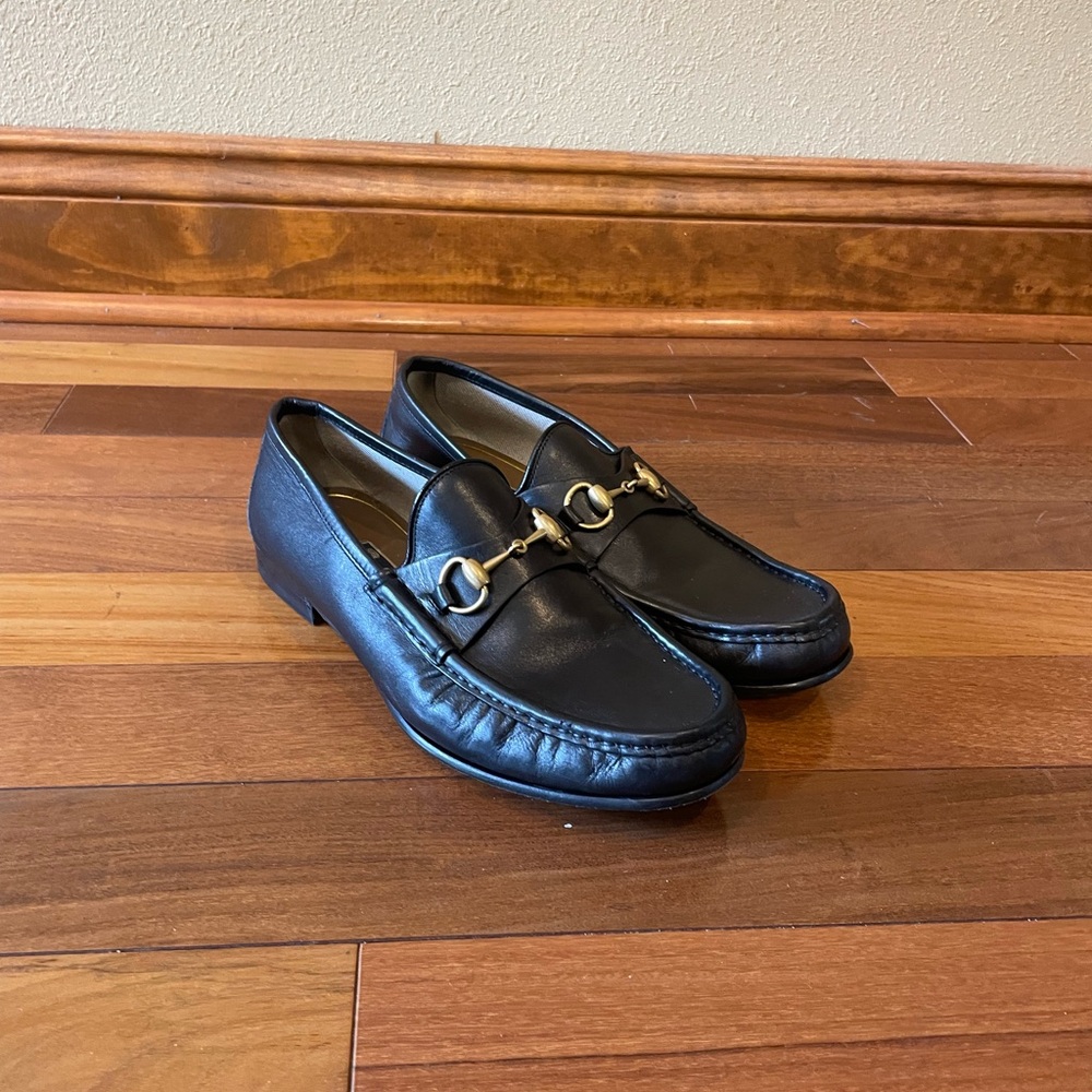 black Gucci loafers with gold hardware